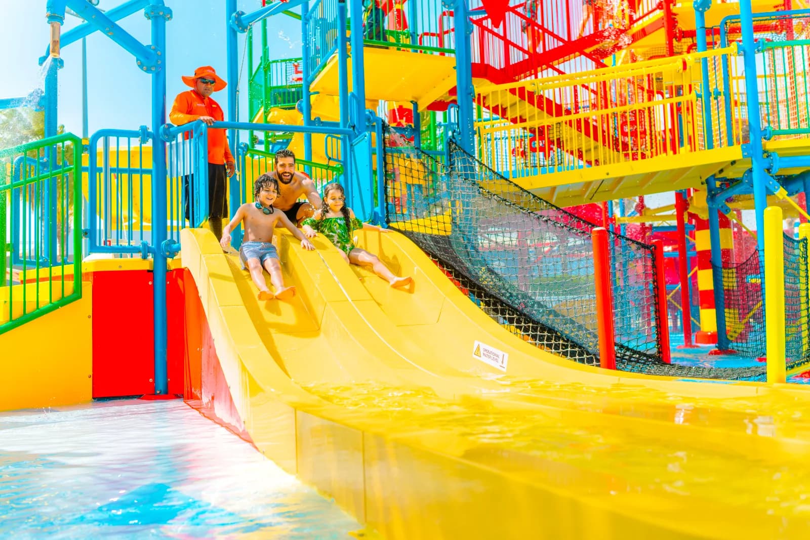 A family sliding together at the colourful Joker Soaker water playground